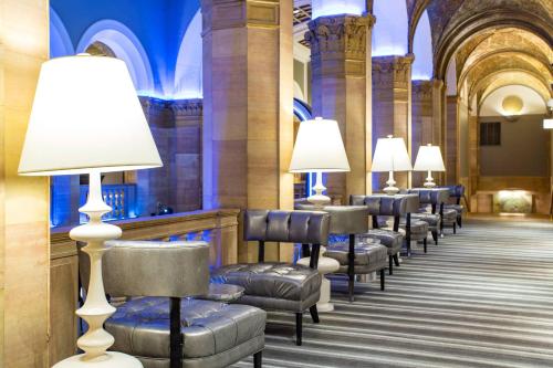 a row of chairs and lamps in a hallway at The Midland Hotel, Chicago, a Tribute Portfolio Hotel in Chicago