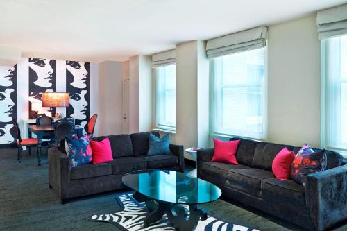 a living room with two couches and a table at The Midland Hotel, Chicago, a Tribute Portfolio Hotel in Chicago