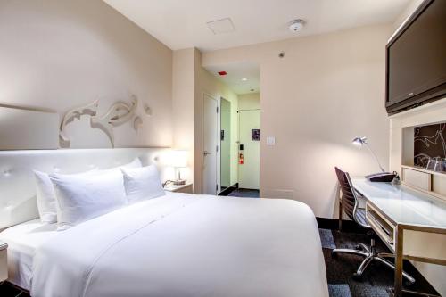 a bedroom with a large white bed and a desk at The Midland Hotel, Chicago, a Tribute Portfolio Hotel in Chicago