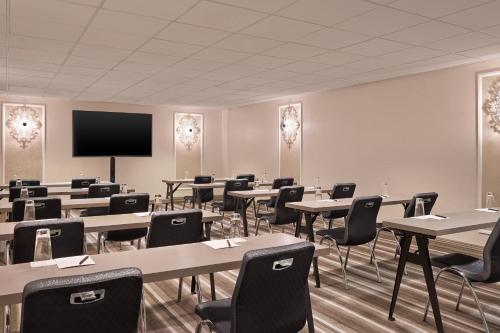 an empty classroom with tables and chairs and a tv at The Midland Hotel, Chicago, a Tribute Portfolio Hotel in Chicago