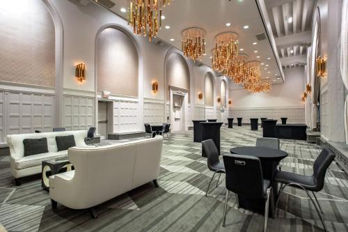 a lobby with a waiting room with chandeliers at The Midland Hotel, Chicago, a Tribute Portfolio Hotel in Chicago