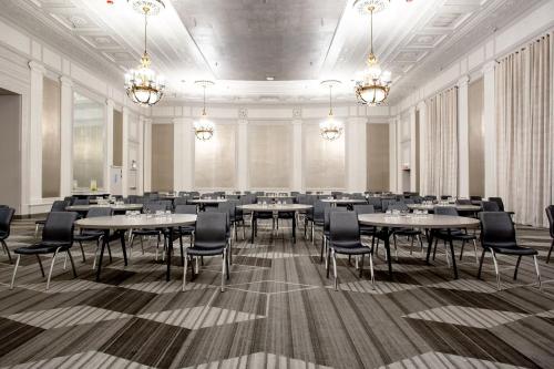 a large room with tables and chairs and chandeliers at The Midland Hotel, Chicago, a Tribute Portfolio Hotel in Chicago