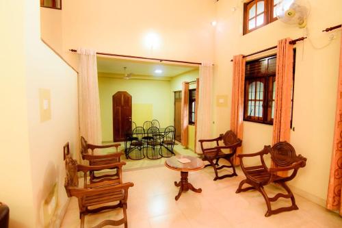 a living room with wooden chairs and a table at The House Dewata in Galle