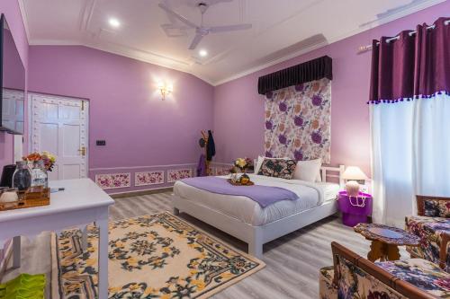 a bedroom with purple walls and a bed in a room at Seclude Tea Estate, Palampur in Pālampur
