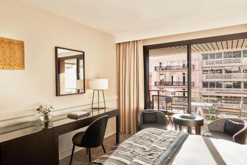 a hotel room with a bed and a desk at Hôtel Barrière Le Gray d'Albion in Cannes