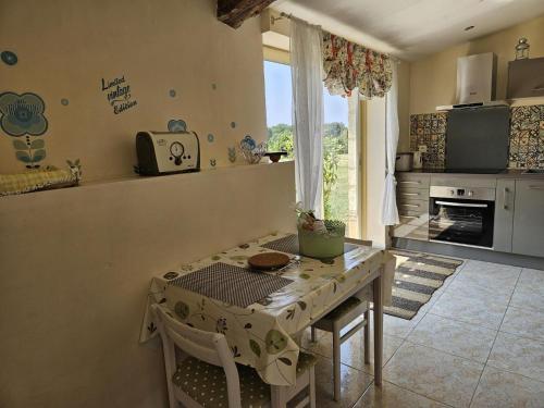 un salon avec une table et une cuisine dans l'établissement Le tilleul, à Saint-Sauveur