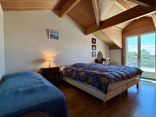 Un dormitorio con dos camas y una gran ventana. en Maison 4 pièces 8 couchages Saint Pierre d'Oléron SPO000-325, en Saint-Pierre-dʼOléron