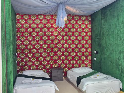 two beds in a room with a red wall at Art Hostel in Tashkent