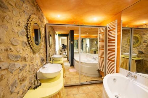 une grande salle de bain avec deux lavabos et une baignoire et un tubermott dans l'établissement Prune, à Saint-Sauveur