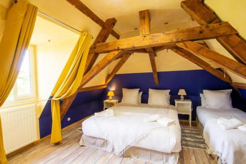 Ce lit se trouve dans un dortoir doté de murs bleus et de parquet. dans l'établissement Prune, à Saint-Sauveur