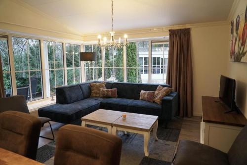 a living room with a couch and a table at EuroParcs Beekbergen in Beekbergen