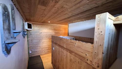 Cette chambre est dotée d'un mur en bois et d'une porte en bois. dans l'établissement Résidence Karen - APPARTEMENT ALPE D'HUEZ COGNET-PIEDS DES PISTES MAE-8911, à Huez