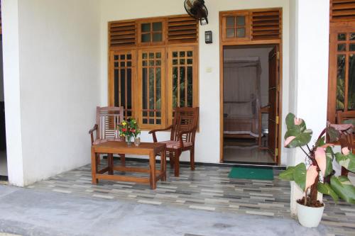 a patio with two chairs and a table on a house at Dilsara Accommodation in Tangalle