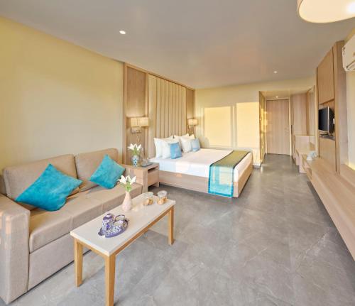 a hotel room with a bed and a couch at Shivsagar Resort & Spa in Mahabaleshwar