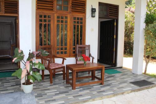 a porch with a table and chairs on a house at Dilsara Accommodation in Tangalle
