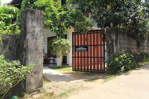 a gate with a sign on it in front of a house at Dilsara Accommodation in Tangalle