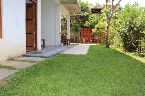 a house with a yard with green grass at Dilsara Accommodation in Tangalle