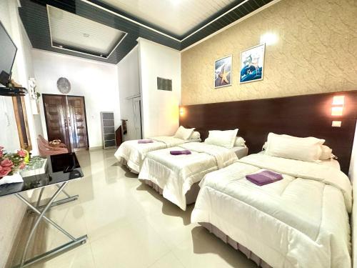 a hotel room with two beds with white sheets at Alya Homestay Meulaboh in Meulaboh