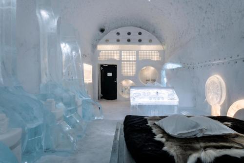 a white room with an ice room with a bed and a table at IceHotel in Jukkasjärvi