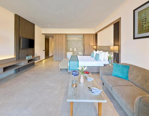 a hotel room with a bed and a couch at Shivsagar Resort & Spa in Mahabaleshwar
