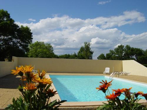 une piscine dans une cour fleurie dans l'établissement La Bergerie, à Deaux