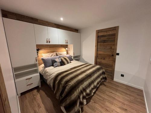 une chambre avec un grand lit et une porte en bois dans l'établissement Le Refuge des Mômes, à Huez