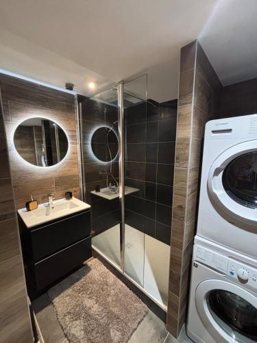 une salle de bain avec un lavabo et une machine à laver dans l'établissement Le Refuge des Mômes, à Huez