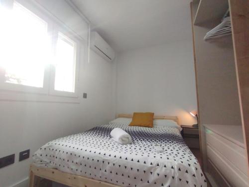 a small bedroom with a bed with a window at Acogedor apartamento en Leganés in Leganés