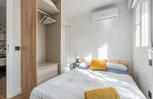 a bedroom with a bed with a yellow pillow on it at Acogedor apartamento en Leganés in Leganés