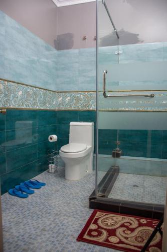 a bathroom with a toilet and a glass shower at 8 bedroom in Nanyuki with pool in Ol Pejeta Conservancy