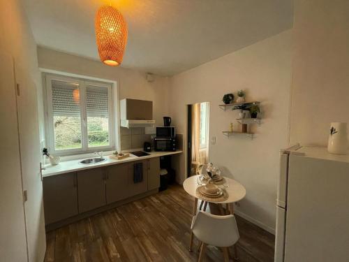 una piccola cucina con tavolo e frigorifero di L 'Écrin Ivoire - Comfort and Productivity -Terrasse a Brive-la-Gaillarde