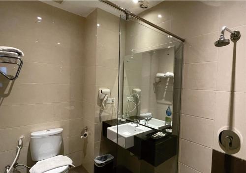 a bathroom with a toilet and a sink and a shower at King's Hotel Nagoya Batam in Nagoya