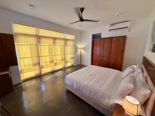 a bedroom with a bed and a ceiling fan at Villa Margot by Ceylon Spaces in Pamunugama
