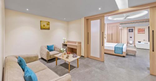 a living room with a couch and a room with a bed at Shivsagar Resort & Spa in Mahabaleshwar