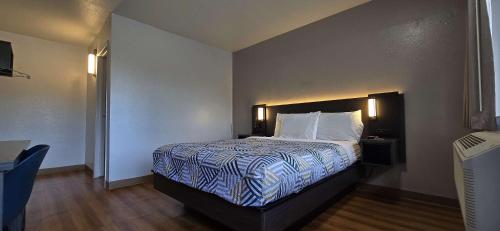 a bedroom with a bed with a blue and white comforter at Motel 6-Slidell, LA - New Orleans in Slidell