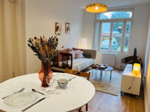 un salon avec une table avec un vase de fleurs dans l'établissement Casa Predali, à Angers