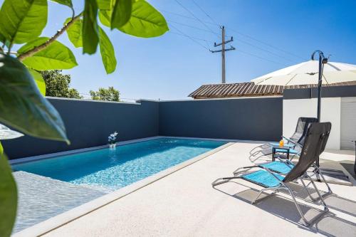 a swimming pool with a chair and an umbrella at Villa Marsel in Mednjan