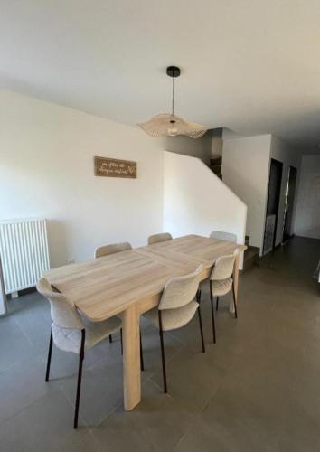 - une table et des chaises en bois dans l'établissement Maison Moderne Saint-Genis-Laval, à Saint-Genis-Laval