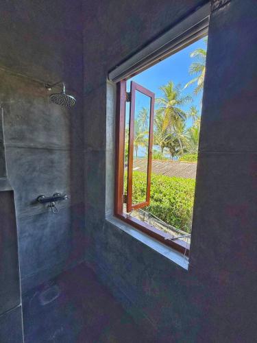 a bathroom with a window and a shower with at Villa Margot by Ceylon Spaces in Pamunugama