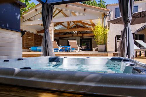 Un bain à remous est installé au milieu d'une terrasse. dans l'établissement Le Clos des Lilas, à Graves