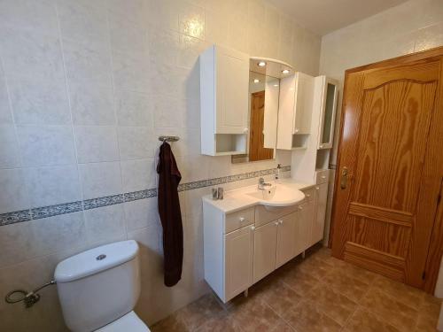 a bathroom with a toilet and a sink and a mirror at Casa La Vista in Canillas de Albaida
