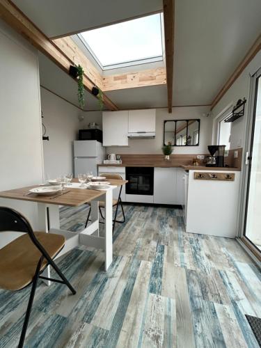 une cuisine avec des armoires blanches et une table et des chaises dans l'établissement La petite saline, au Croisic