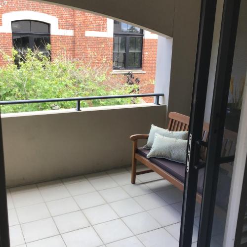 a balcony with a bench and a window at Bannister Street Apartments in Fremantle