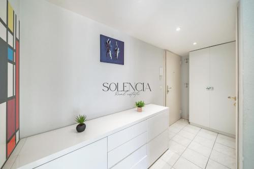 Cette chambre est dotée d'un mur blanc avec un panneau. dans l'établissement 2 pièces - Très proche Croisette et Palais des Festivals, à Cannes