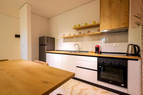 a kitchen with a stove and a sink and a table at SanPietro Vacation Apartments in Durrës
