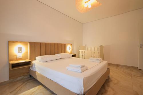 a bedroom with a large bed with towels on it at SanPietro Vacation Apartments in Durrës