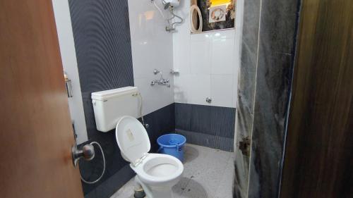 a small bathroom with a toilet and a shower at Harsh angel holiday homes in Calangute