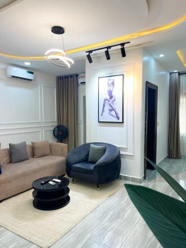 a living room with a couch and a chair at Fully Furnished Modern 2 bedroom in jahi in Abuja