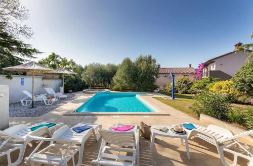 una piscina con sedie a sdraio e una piscina di Sabi Relax Zone - Pool & Jacuzzi a Pola (Pula)