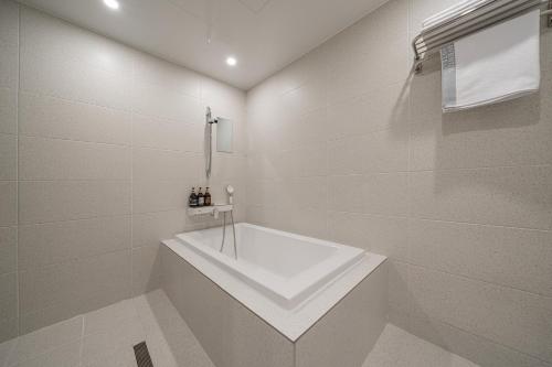 a white bathroom with a tub and a sink at Cheonan H-Avenue Cheonan Buldang in Cheonan